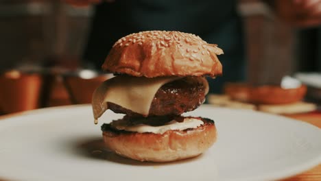 El-Chef-Coloca-Un-Panecillo-De-Hamburguesa-A-La-Parrilla-Encima-De-Una-Hamburguesa-Recién-Cocinada