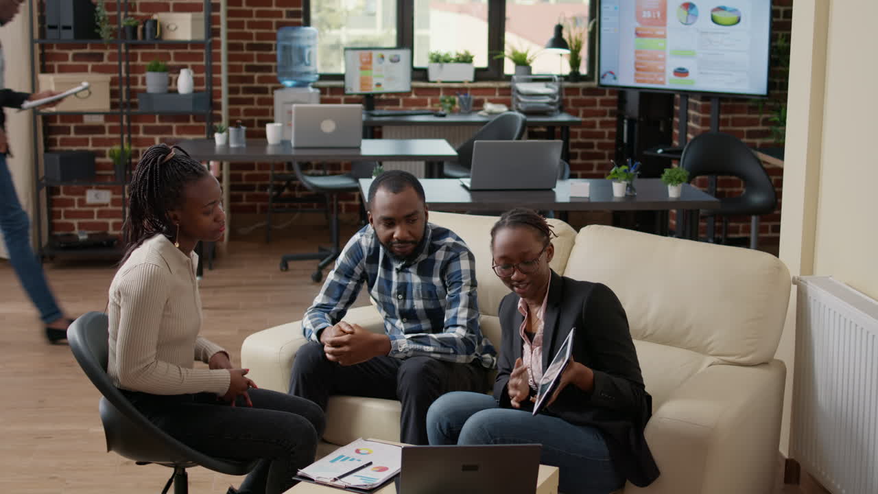 Office workers looking at financial statistics on digital tablet