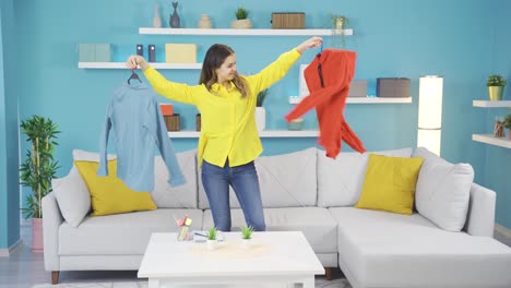 una chica joven tratando de elegir ropa bailando.