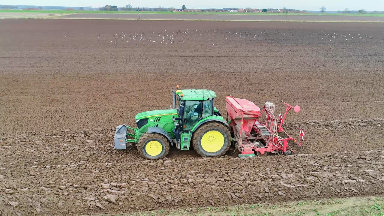 Seed drill being pulled by a tractor sowing the next crop of wheat.