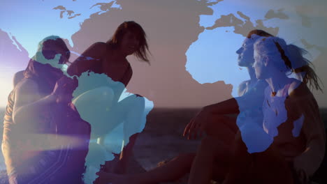 animation of world map and glowing network over happy female friends talking on beach