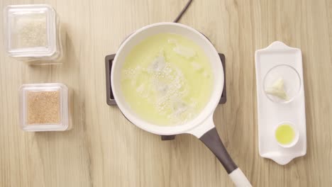 Frying-Ramadan-Briwat-in-white-pot-with-burning-oil,-top-shot-static