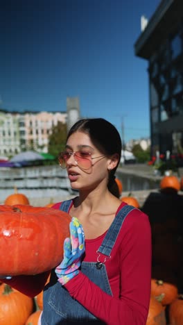 woman holding a pumpkin at an outdoor market