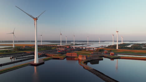 aerial view of wind turbines and canal at sunset