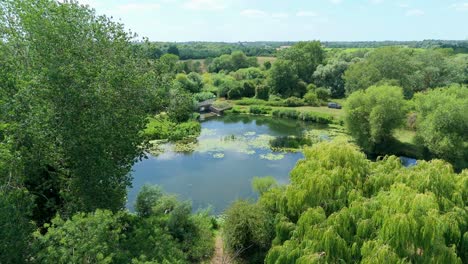 aerial drone footage of a scenic wetland river landscape and weir near the offords in cambridgeshire england