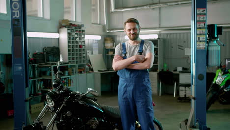 man in blue overalls with arms crossed