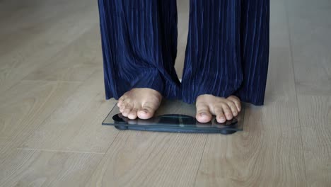 woman standing on a scale in a bathroom