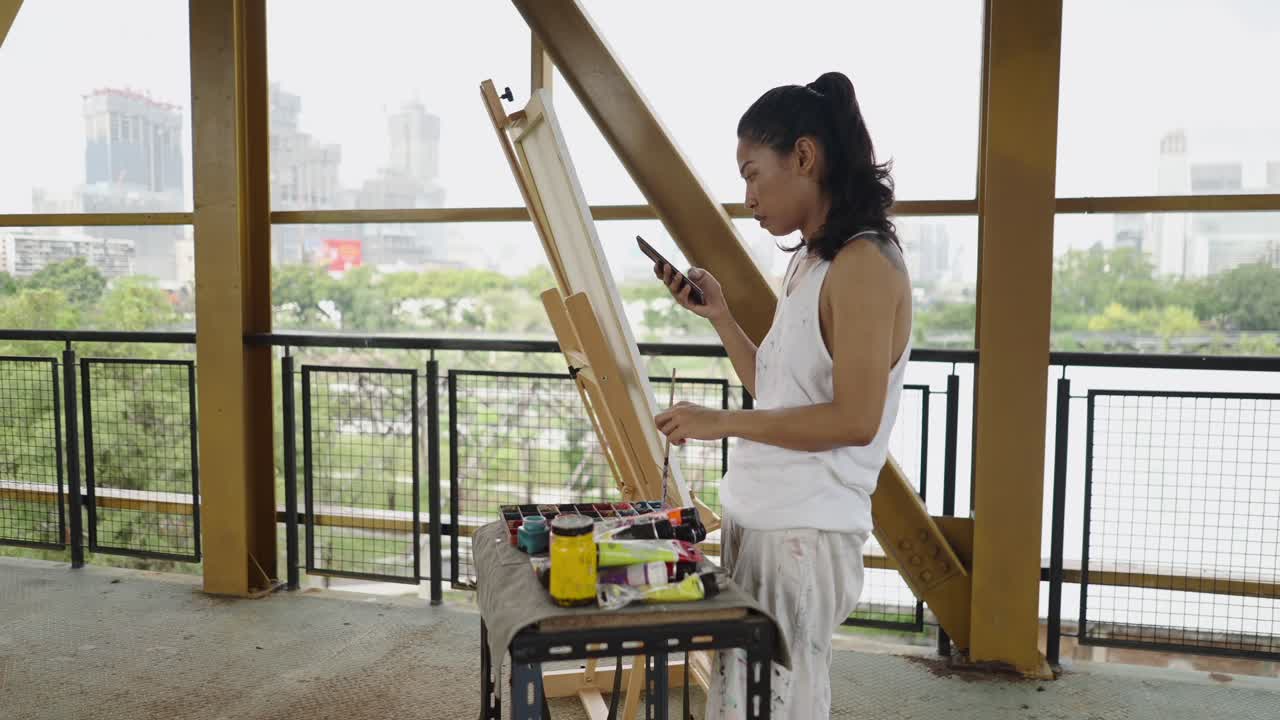 Woman Painting Outdoors with Art Supplies and Smartphone