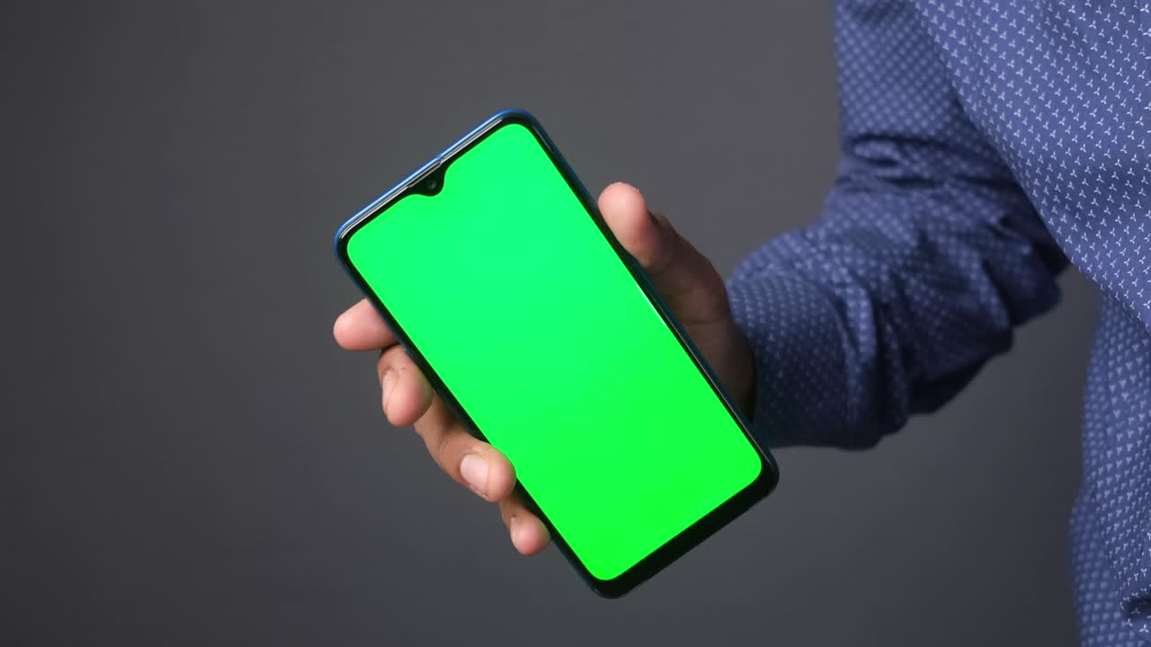 close up de la mano de un joven usando un teléfono inteligente con pantalla verde