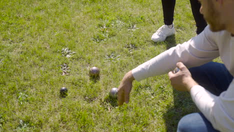 top view of a caucasian young man calculating distance between petanque balls in the park