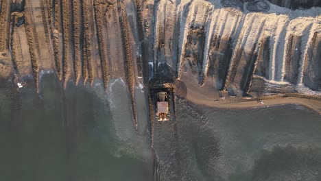 bulldozer carrying sand to shore