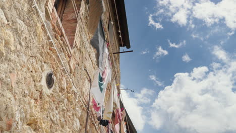 Traditional-Italian-stone-house-with-hanging-laundry-under-a-blue-sky