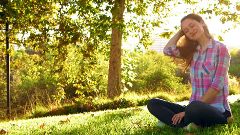 mujer sentada y sonriendo en paz con la vida en el parque