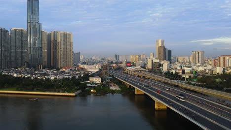 Aerial-view-of-traffic-on-the-QL52-highway,-golden-hour-in-Ho-chi-minh,-Vietnam---low,-tracking,-drone-shot