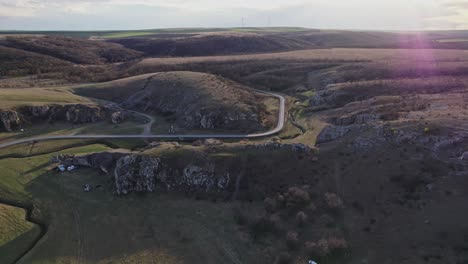 las gargantas de dobrogea durante la puesta de sol con un camino sinuoso a través de un terreno montañoso, vista aérea