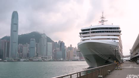 a cruise ship is seen moored at ocean terminal at victoria harbour as hong kong's skyline is seen in the background