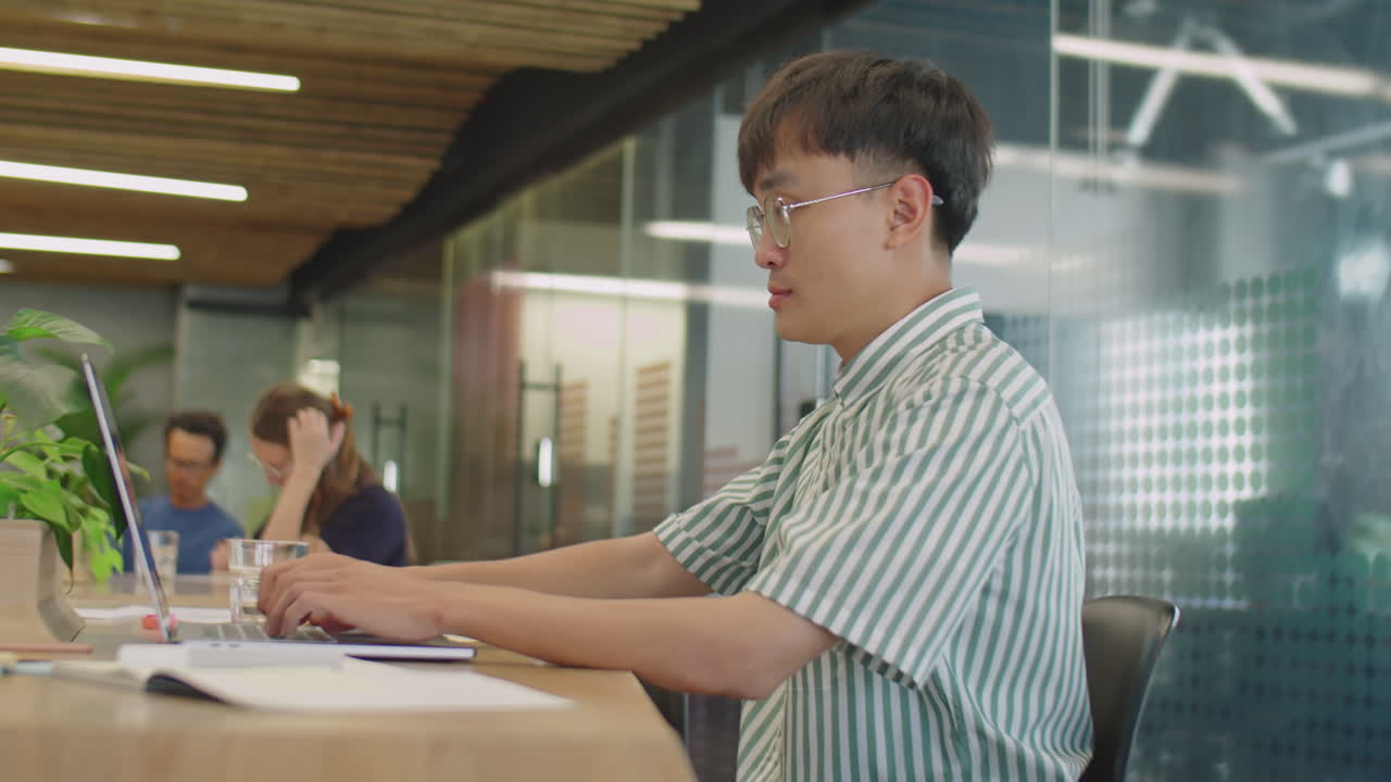 코워킹룸에서 노트북을 사용하는 Z세대 아시아 남성