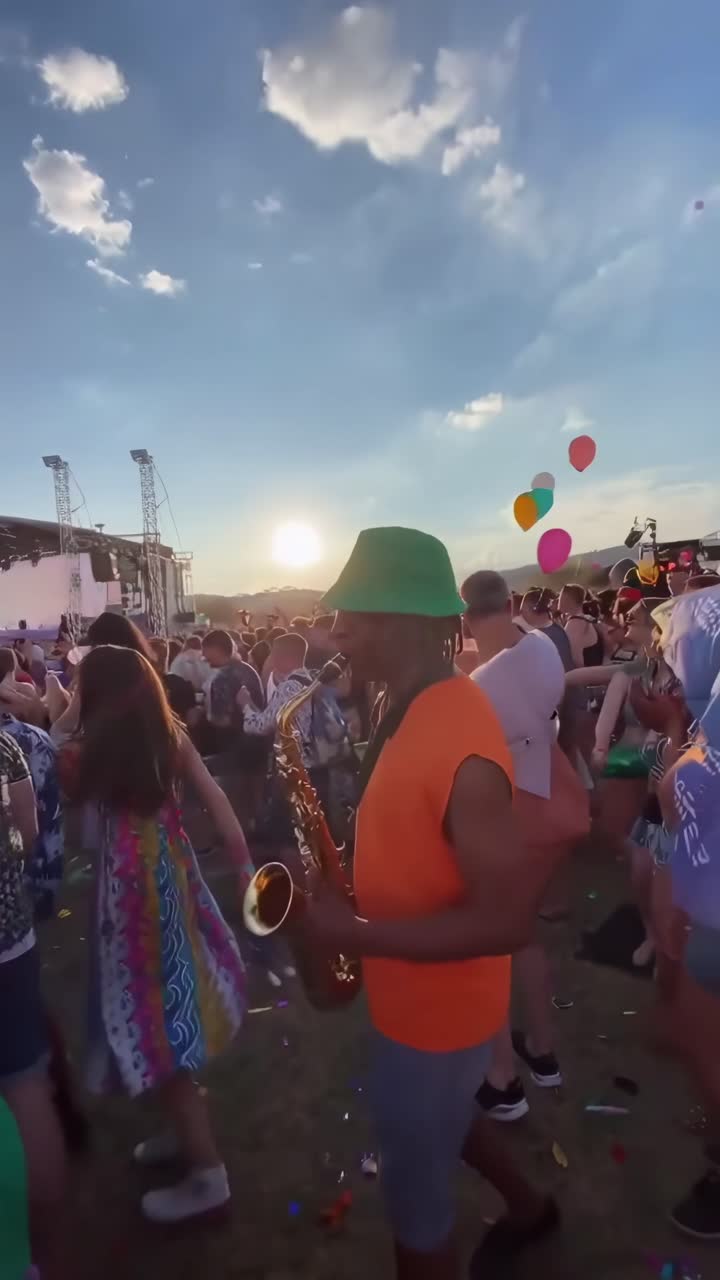 Folla vivace che balla a un festival musicale all'aperto al tramonto