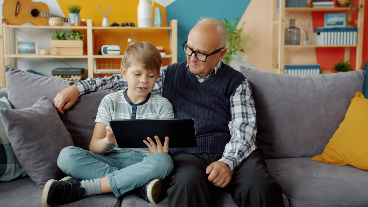 Grandfather and grandson using a tablet