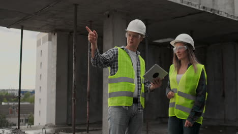 ingenieros o arquitectos tienen una discusión en el sitio de construcción mirando a través del plan de construcción. contre jour. ingenieros o arquitectes tienen una discusion