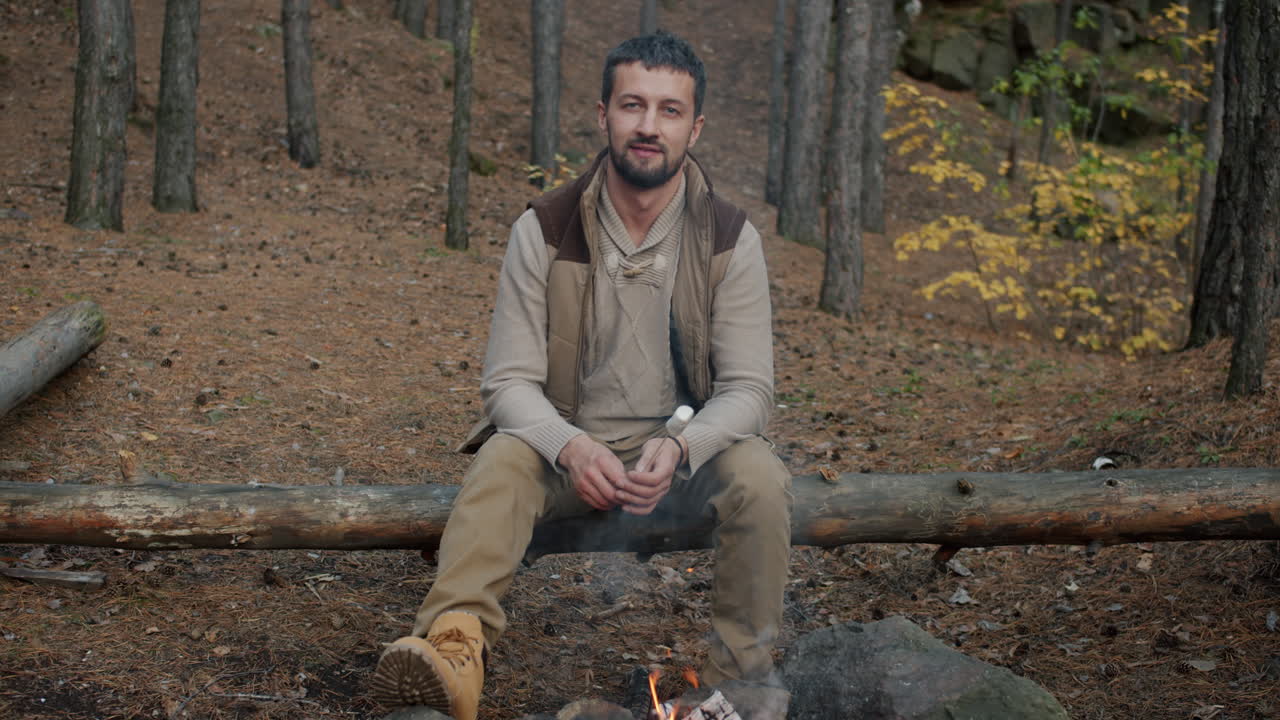 Man sitting by a campfire in the forest