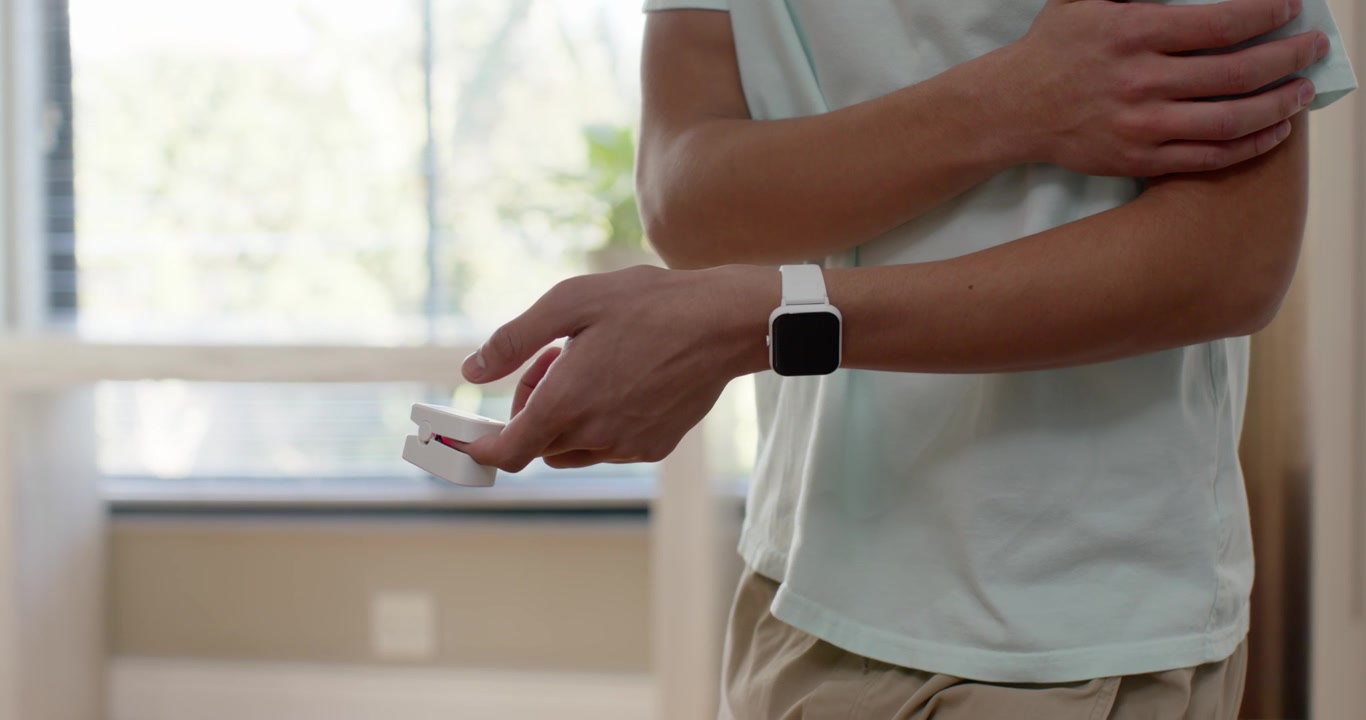 Uomo afroamericano che aggiusta la presa, rivelando uno smartwatch, preparando il dispositivo vicino alla finestra, spazio per il testo
