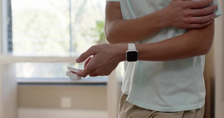 Uomo afroamericano che aggiusta la presa, rivelando uno smartwatch, preparando il dispositivo vicino alla finestra, spazio per il testo