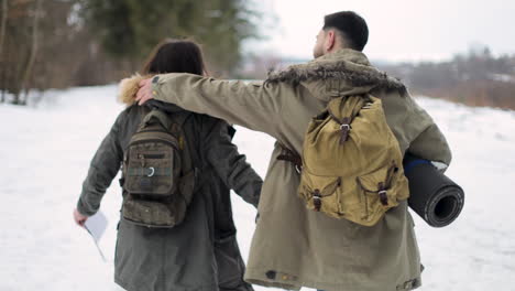 pareja caucásica caminando en un bosque nevado.