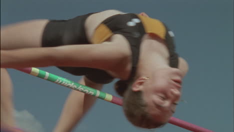 a woman athlete performs a high jump