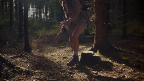 Woman-resting-while-sitting-on-rock-in-forest