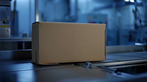 cardboard box moving on a conveyor belt in a factory setting