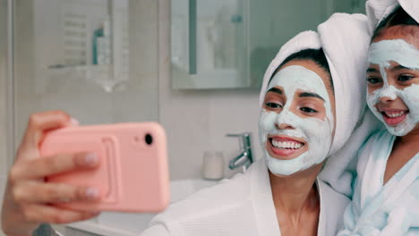 mother and daughter taking a selfie with facial masks