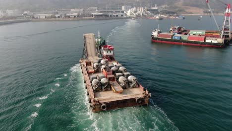 Lastkahn-Beladen-Mit-Betonmischern,-Die-Von-Einem-Schlepper-In-Der-Bucht-Von-Hongkong-In-Den-Hafen-Gezogen-Werden,-Luftbild