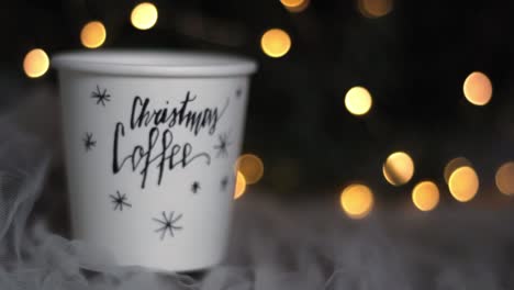 christmas decor coffee paper cup on a cozy bed, closeup handheld