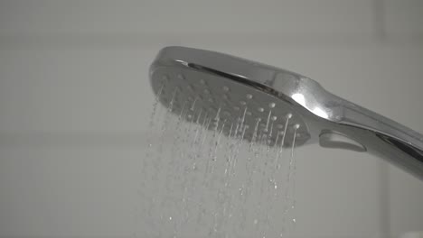 a shower head lets out water in super slow motion