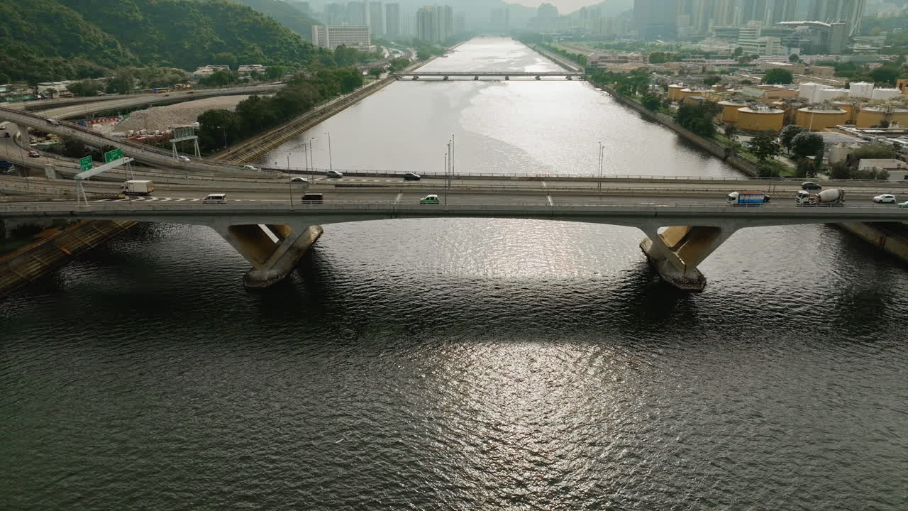 홍콩의 넓은 수로 다리를 통해 고속도로에서 운전하는 공중 틸트 샷 자동차