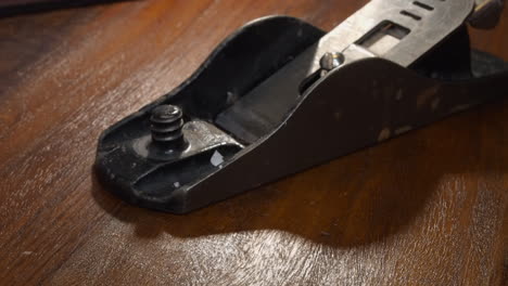 closeup view of vintage wood plane being reassembled, test sharp blade