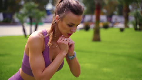 mujer haciendo ejercicio al aire libre en traje de fitness púrpura