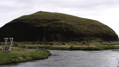 río y colina volcánica en un día húmedo en el paisaje de islandia