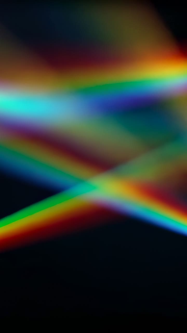 Video verticale: fasci arcobaleno che attraversano uno sfondo scuro, fotogrammi che avanzano e si incrociano