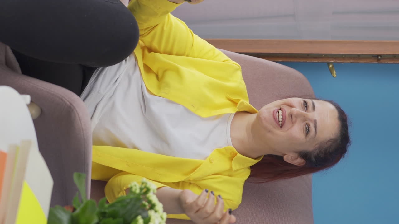 집에서 춤을 추는 행복한 여성의 수직 비디오.