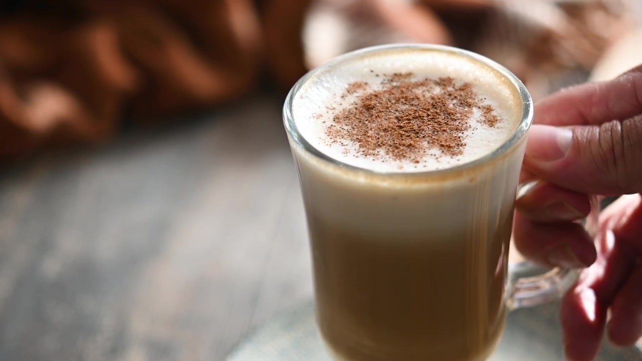 Latte d'acero con cannella in tazza di vetro