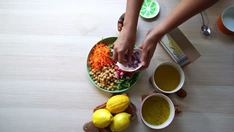 Hinzufügen-Von-Zwiebeln-Zum-Salat-Luftaufnahme-Herstellung-Eines-Salats-Hinzufügen-Von-Tomaten,-Karotten,-Spinat,-Kichererbsen,-Zitronen,-Zwiebeln,-Nüssen,-Dressing-Im-Blick