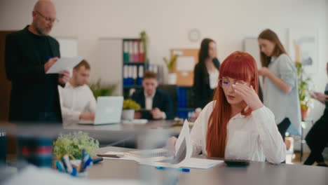 Worried-female-employee-examining-documents-in-office.