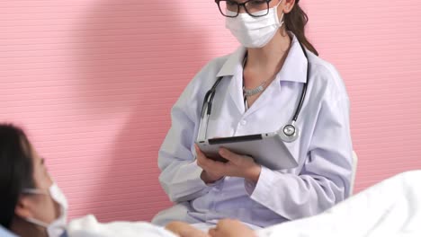 doctor wearing face mask proficiently talks with patient at hospital ward