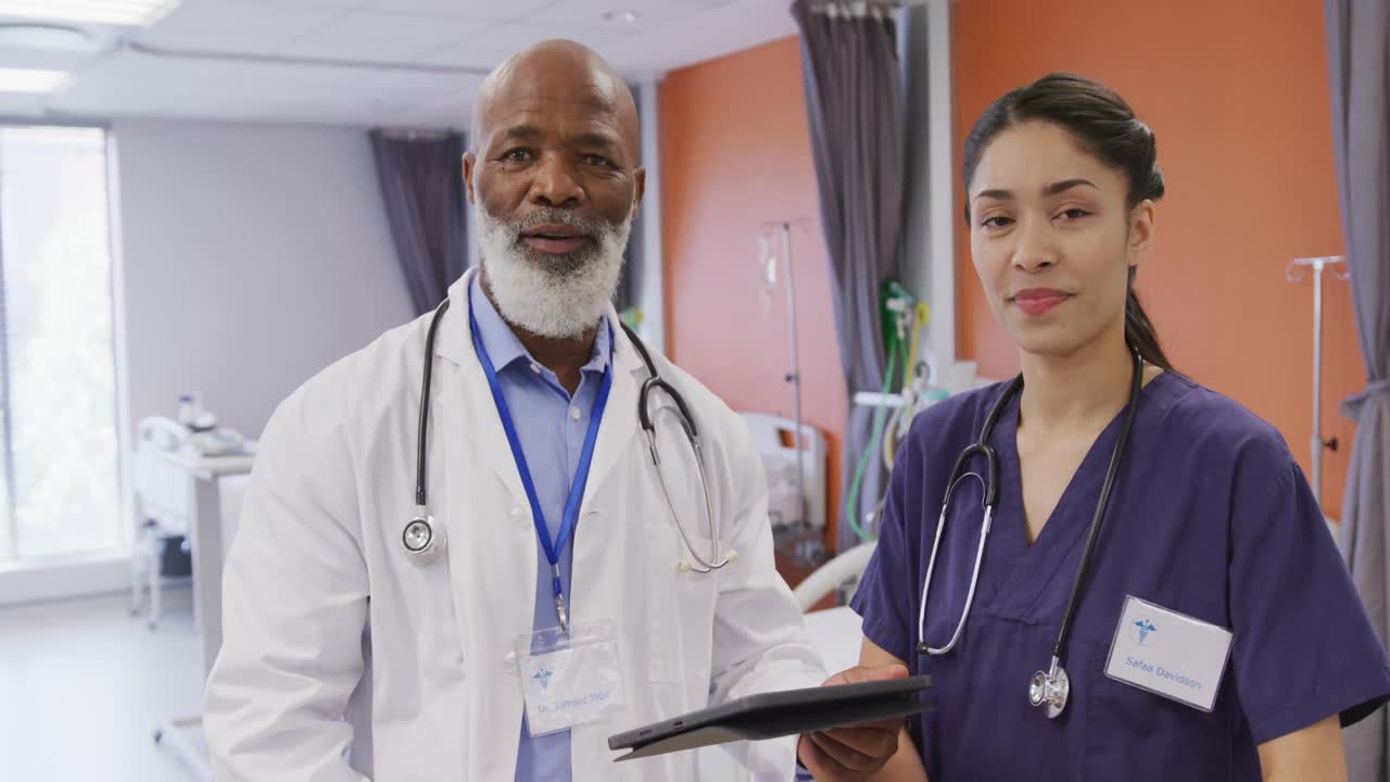 Portrait of diverse male and female doctors using tablet at hospital