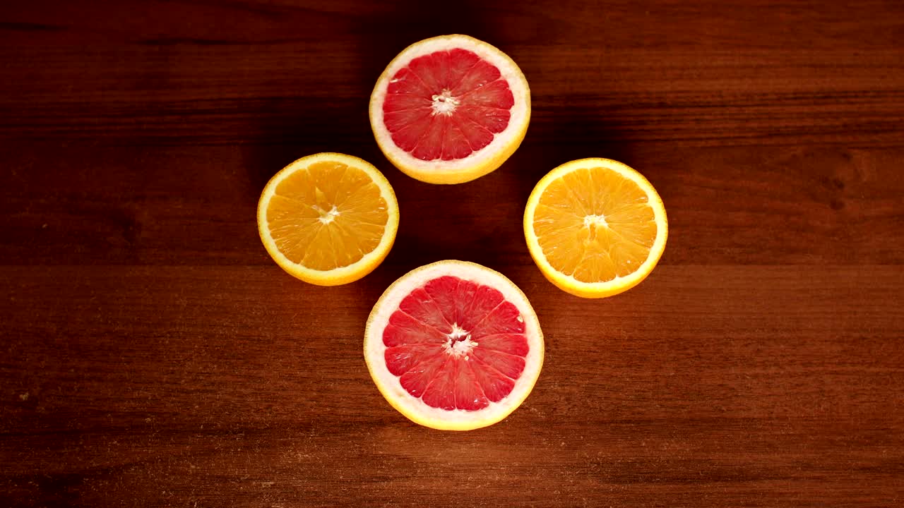 Girl takes half of the grapefruit from the table.
