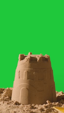 Vertical-Video-Summer-Holiday-Concept-Making-Sandcastle-On-Sandy-Beach-Against-Green-Screen-1