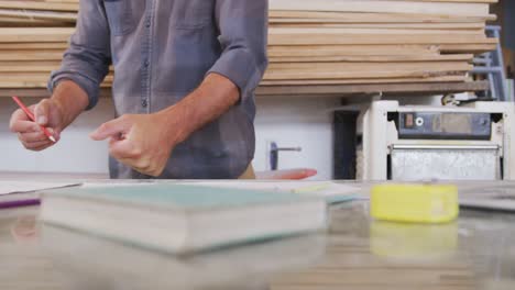 Kaukasischer-Männlicher-Surfbrettbauer,-Der-In-Seinem-Studio-Arbeitet