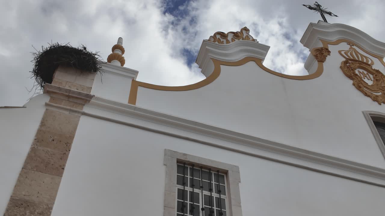 Igreja Matriz facade with crest and cross in Portimão Portugal under clouds